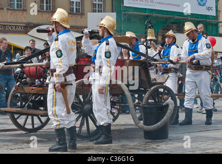 Volunteer village firefighters in historic uniforms old fire engine at street show on Firefighters Day, Rynek in Wrocław, Poland Stock Photo