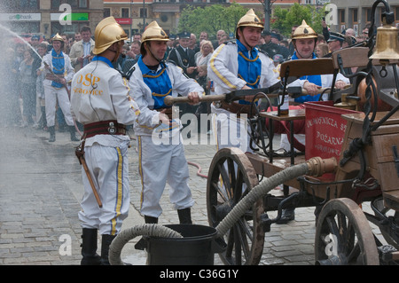 Volunteer village firefighters in historic uniforms old fire engine at street show on Firefighters Day, Rynek in Wrocław, Poland Stock Photo