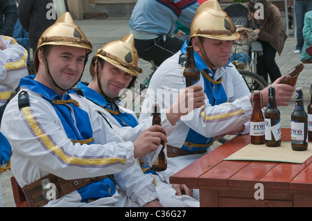 Volunteer village firefighters in historic uniforms drinking beer at street show on Firefighters Day at Rynek in Wrocław, Poland Stock Photo