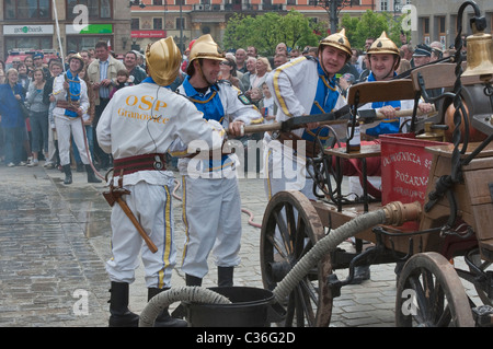 Volunteer village firefighters in historic uniforms old fire engine at street show on Firefighters Day, Rynek in Wrocław, Poland Stock Photo