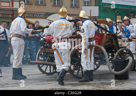 Volunteer village firefighters in historic uniforms old fire engine at street show on Firefighters Day, Rynek in Wrocław, Poland Stock Photo