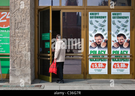 Customer entering bank, poster with actor Antonio Banderas surrounded by zloty bank notes, Bank Zachodni WBK in Wrocław, Poland Stock Photo
