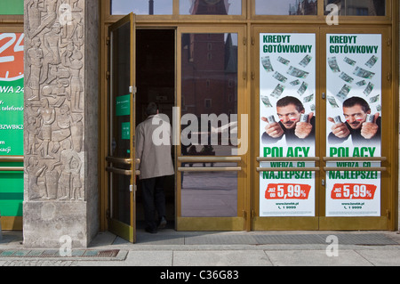 Customer entering bank, poster with actor Antonio Banderas surrounded by zloty bank notes, Bank Zachodni WBK in Wrocław, Poland Stock Photo