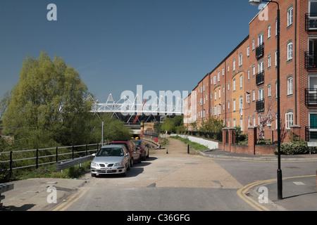 View towards the 2012 London Olympic stadium past local flats on Blaker Road,  Stratford, East London, UK. Stock Photo