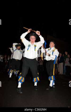 The Ravensbourne Morris Men perform at night outside a pub in North West Kent, UK. Stock Photo