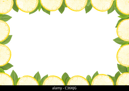 frame made of yellow lemon slices and green leaves on white background Stock Photo