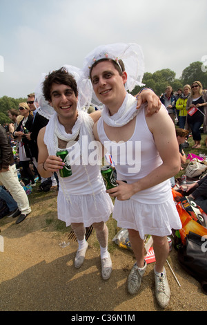 Royal wedding cross dressing, transvestite cross dressed male revellers dressed as brides drinking cans of lager, Hyde Park, London, UK Stock Photo