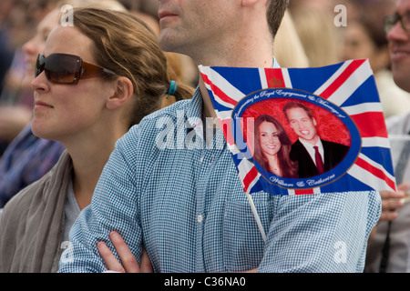 Royal wedding revellers holding flag with Prince William and Catherine Middleton celebrate in Hyde Park London UK Stock Photo
