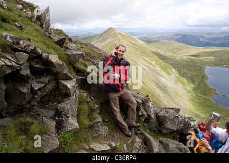 Prince William conducts a satellite-phone interview on Swirral Edge on the route up to the summit plateau of Helvellyn, Cumbria, Stock Photo