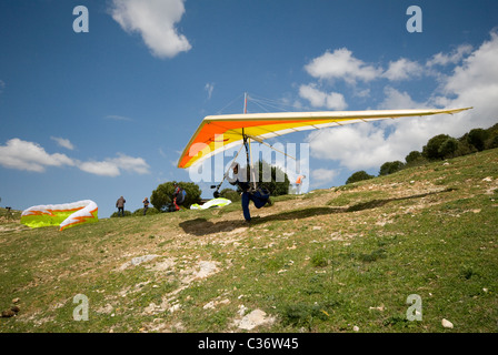 Hang glider pilot taking off from slope Stock Photo