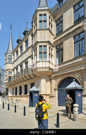 Tourist taking picture of guard in front of the Grand Ducal Palace / Palais grand-ducal at Luxembourg, Grand Duchy of Luxembourg Stock Photo