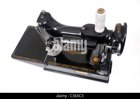 Vintage Singer sewing machine threaded with spool of white thread on white background,  cutout. Stock Photo