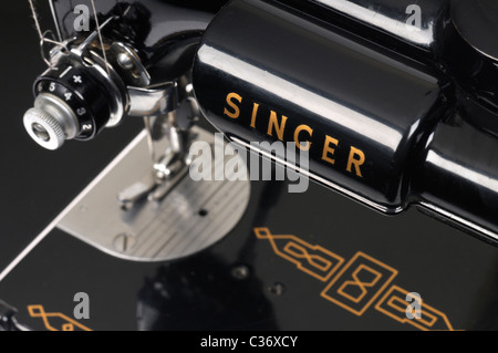 Threaded needle and bobbins spooled with thread of an antique Singer sewing machine close-up. Stock Photo