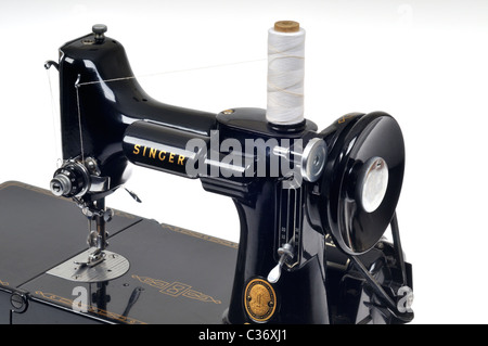 Vintage Singer sewing machine threaded with spool of white thread on white Stock Photo