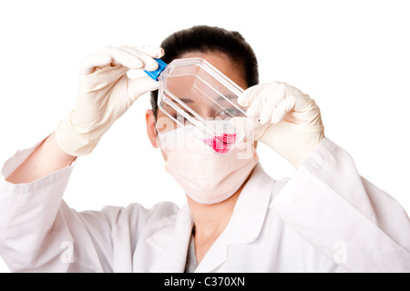 Female scientist researcher looking at red tissue cell culture medium in flask wearing gloves and mouth cap, isolated. Stock Photo