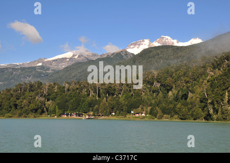 Blue view, from Lago Frias, of Volcan Tronador rising above the Andean Rain Forest mountain shoreline at Puerto Frias, Argentina Stock Photo