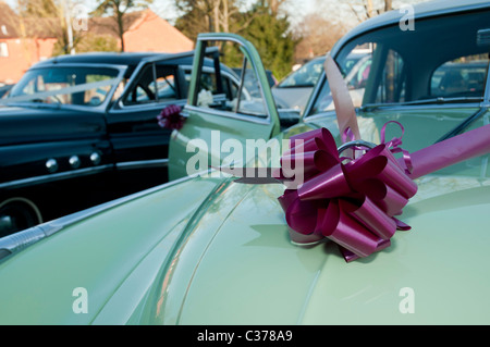 old american buick vintage car used for a wedding car with detail of chrome on door handle with bouquet of burgundy flowers Stock Photo