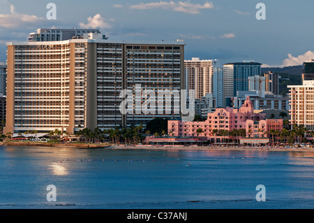 A view of the Sheraton Waikiki hotel (left) and the iconic art deco pink Royal Hawaiian Hotel on the shoreline of Waikiki Beach, Stock Photo