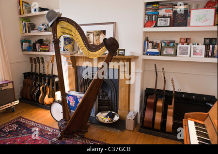 Music room with concert triple harp vintage guitars and piano in musician's house with feature period fireplace Stock Photo