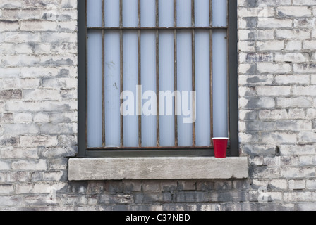 A barred window and a red mug in Indianapolis, USA. Stock Photo