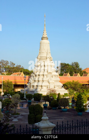 A white Buddhist stupa is illuminated by late afternoon sun at The Royal Palace complex in Phnom Penh, Cambodia. Stock Photo