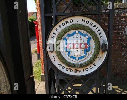 Old metal sign on one of the wrought iron entrance gates to the former Seckford (Sekford) Hospital, Woodbridge, Suffolk Stock Photo