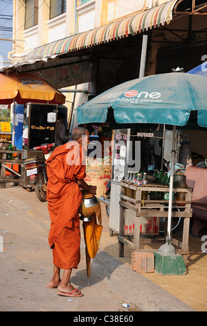 Elderly Buddhist monk collecting alms in a street in Kampot Southern Cambodia. Stock Photo