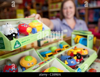 An Early Learning Centre employee tidies shelves on the shop floor, Kensington, London. Stock Photo