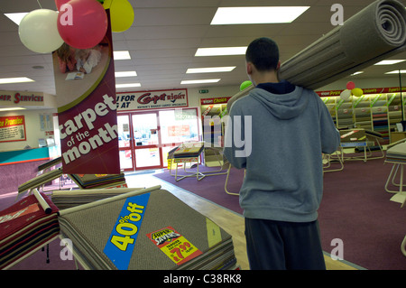 Carpet Right: A Customer carrying his purchase through a Carpet Right store Stock Photo