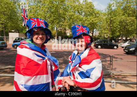 Two happy royal wedding spectators on The Mall a day before the big event in central London, dressed in union flags. Stock Photo