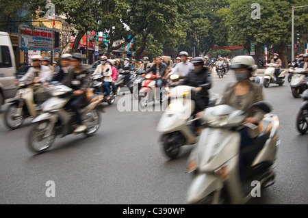 Horizontal wide angle of disorganised chaos on the streets of Hanoi with mopeds, motorbikes & scooters everywhere at rush hour Stock Photo