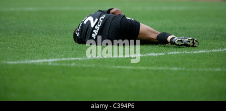 Injured football player lying on the pitch Stock Photo