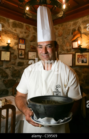 Portrait of chef holding food casserole in a restaurant Stock Photo
