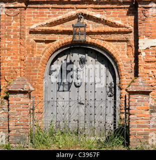 An old wooden double-door in an old brick building. Stock Photo