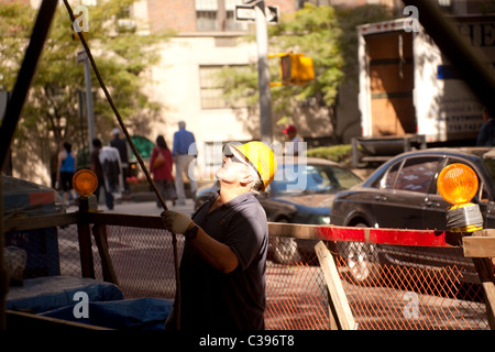 Building worker wearing a protective helmet on building site in Manhattan Stock Photo