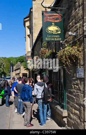 Tourists on the pavement ouside The Old Original Bakewell Pudding Shop, Bakewell, The Peak District, Derbyshire, UK Stock Photo