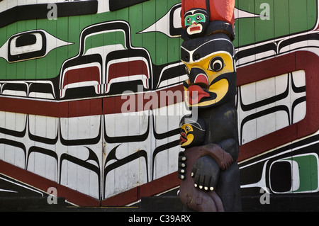 Native American art on side of building and totem pole in Victoria, British Columbia, Canada. Stock Photo