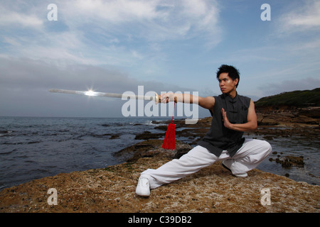 Chinese man doing martial arts and pointing sword Stock Photo