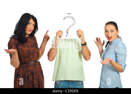 Surprised two women pointing to unknown guy who hold a question mark in front of his face isolated on white background Stock Photo