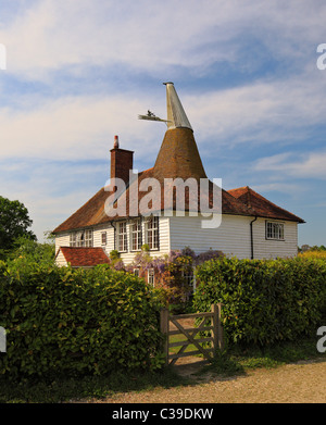 Unusual looking old Oast house with a square and round roof. Stock Photo