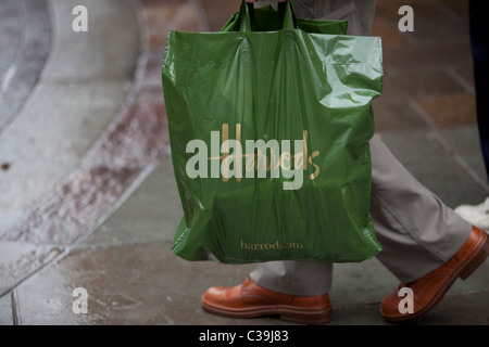 Harrods customers with their purchases in the un-mistakable green Harrods carrier bag. Stock Photo