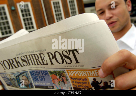 a man reading a copy of the Yorkshire Post newspaper, a Johnston Press publication. Stock Photo