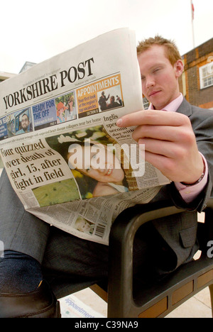 a man reading a copy of the Yorkshire Post newspaper, a Johnston Press publication. Stock Photo