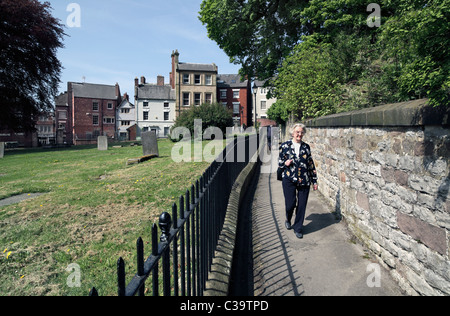 Church Walk, Wirksworth, Derbyshire - a footpath route around the churchyard (left) of St Mary's Church, next to the town centre Stock Photo