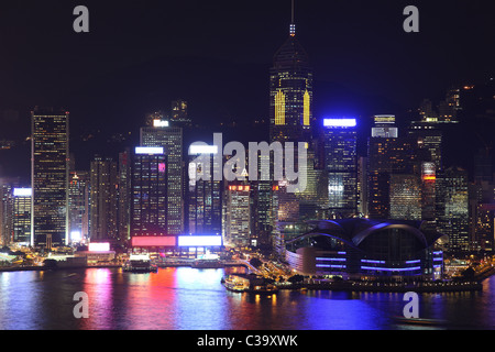 Illuminated Hong Kong Island skyline with reflections at night Stock Photo