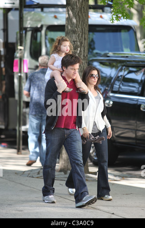 Jason Bateman carries his daughter, Francesca, on his shoulders while walking with his wife Amanda Anka during a break at the Stock Photo