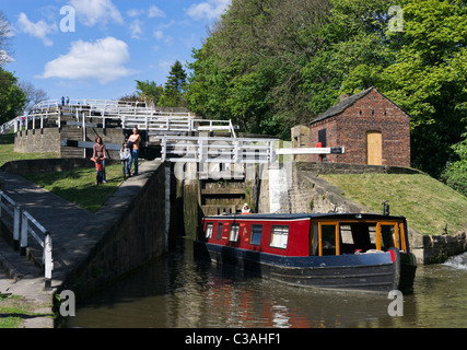 Narrowboat leaving the last of the Five Rise Locks on the Leeds and Liverpool Canal, Bingley, West Yorkshire, UK Stock Photo