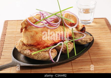 Roast chicken and potatoes on a skillet Stock Photo