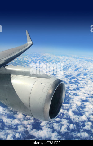 airplane wing aircraft turbine flying blue sky white clouds Stock Photo