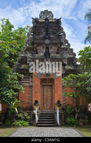 Ornate hand carved stone gate with Barong face of PURA DESA UBUD, the main Hindu temple of the town - UBUD, BALI Stock Photo